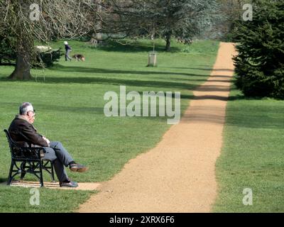 Bury Knowle Park à Oxford est un havre peu connu de paix et de tranquillité juste à côté de la cowley Road animée près du centre-ville d'Oxford. Ici, nous voyons un couple se détendre par un sentier qui traverse le parc au printemps. Banque D'Images
