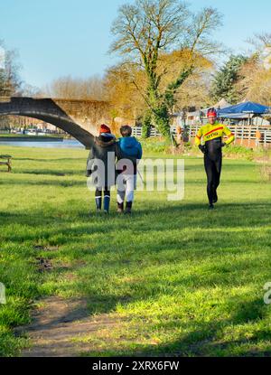 Abingdon prétend être la plus ancienne ville d'Angleterre. C'est son célèbre pont de pierre médiéval, vu par un beau matin d'été. Le pont a été commencé en 1416 et achevé en 1422, en utilisant du calcaire local. Ici, nous voyons un couple câlin marchant sur les rives de la Tamise vers le pont au lever du soleil. Banque D'Images