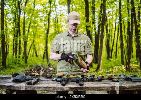 Le gars dans les bois est le nettoyage de son arme Banque D'Images