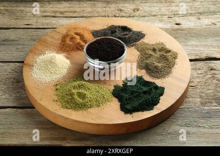 Différentes poudres de superaliments colorées sur table en bois Banque D'Images