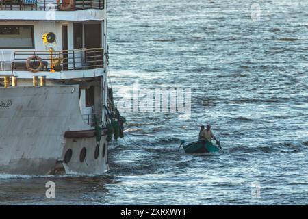 Louxor, Égypte ; 16 janvier 2024 : assistez à la vie quotidienne animée sur le Nil alors que les vendeurs locaux en petits bateaux offrent leurs marchandises aux passagers de croisière. Banque D'Images