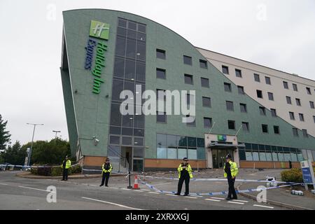Photo du dossier datée du 05/08/24 des policiers du Holiday Inn Express à Tamworth, Staffordshire, après qu'une foule l'ait attaqué. Un couple fait partie des quatre personnes qui ont été placées en détention provisoire suite à des accusations de lancement de briques, de missiles et de désordre de diffusion en direct sur TikTok. Les quatre accusés ont comparu lundi au tribunal de première instance de Cannock avec des accusations relatives à la violence vue à Tamworth et Stoke-on-Trent les 3 et 4 août. Date d'émission : lundi 12 août 2024. Banque D'Images
