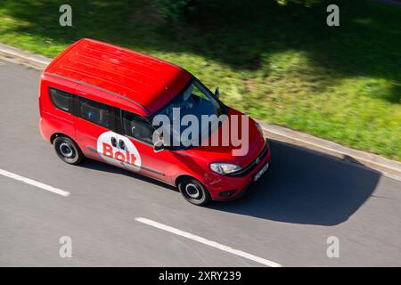 OSTRAVA, RÉPUBLIQUE TCHÈQUE - 12 JUIN 2024 : fourgon compact Fiat Doblo rouge de la compagnie de taxi Bolt avec effet de flou de mouvement Banque D'Images