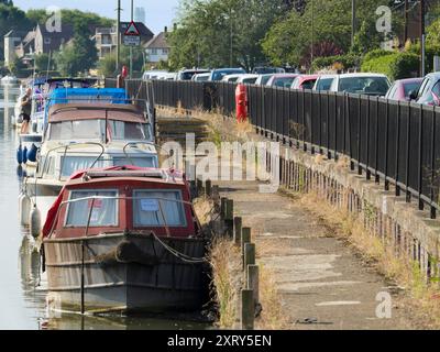 Lignes de voitures et bateaux de plaisance par la Tamise à Abingdon. Abingdon prétend être la plus ancienne ville d'Angleterre. Et c'est la vue sur Wilsham Road par la Tamise vers sa marina chic, bordée de voitures garées et de bateaux de plaisance amarrés, par un beau matin d'hiver. Banque D'Images