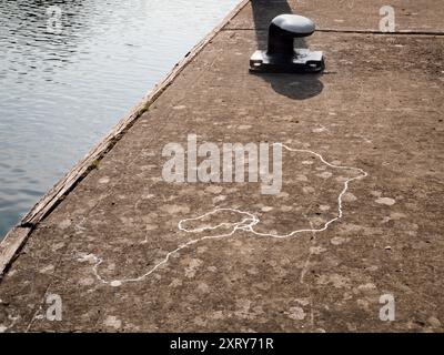 Poste d'amarrage et pistes de limaces près de la Tamise. Gros plan du poste d'amarrage près des portes d'écluse d'Abingdon par un beau matin d'été ; ces écluses pittoresques sont sur la Tamise juste en amont du célèbre pont médiéval en pierre d'Abingdon. Une limace a été là, laissant ces traces scintillantes. Banque D'Images