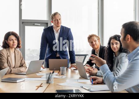 Les professionnels d'affaires s'engagent dans la réunion pendant la journée dans Modern Office Banque D'Images