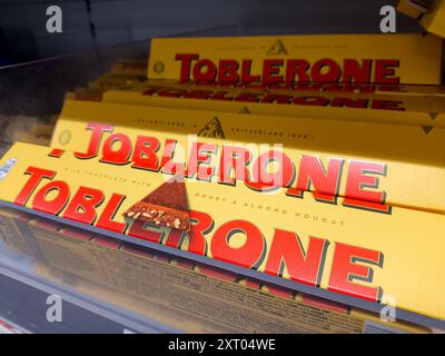 Bavière, Allemagne - 12 août 2024 : les tablettes de chocolat Toblerone dans leur emballage triangulaire emblématique apparaissent sur les rayons des supermarchés *** Toblerone-Schokoladenriegel in ihrer ikonischen dreieckigen Verpackung stehen im Supermarktregal Banque D'Images