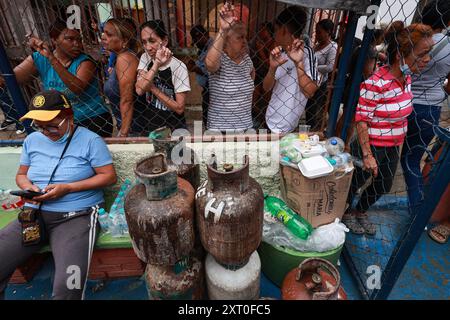 Caracas, Venezuela. 12 août 2024. Les habitants se rassemblent autour de bouteilles de gaz après une explosion dans le quartier de la Unión de Petare dans l’état de Miranda, à l’est de Caracas. Il y a eu plusieurs victimes au Venezuela à la suite d'une explosion de gaz dans un immeuble d'habitation. Crédit : Jesus Vargas/dpa/Alamy Live News Banque D'Images