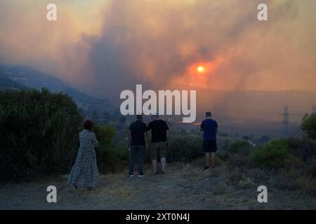 Athènes, Grèce. 12 août 2024. Les résidents observent le front de feu à l'approche de la banlieue de Penteli dans la capitale grecque. Un feu de forêt qui a éclaté à Varnavas le 11 août a continué de faire rage dans l'est de l'Attique le 12 août, attisant et s'étendant sur un front s'étendant sur plus de 20 kilomètres. Plusieurs pays ont répondu positivement à la demande d'assistance du mécanisme de protection civile de l'UE (EUCPM) formulée par les autorités grecques pour lutter contre les incendies de forêt qui font rage. Crédit : Dimitris Aspiotis/Alamy Live News Banque D'Images