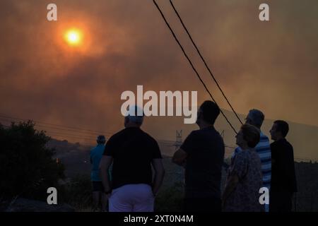 Athènes, Grèce. 12 août 2024. Les résidents observent le front de feu à l'approche de la banlieue de Penteli dans la capitale grecque. Un feu de forêt qui a éclaté à Varnavas le 11 août a continué de faire rage dans l'est de l'Attique le 12 août, attisant et s'étendant sur un front s'étendant sur plus de 20 kilomètres. Plusieurs pays ont répondu positivement à la demande d'assistance du mécanisme de protection civile de l'UE (EUCPM) formulée par les autorités grecques pour lutter contre les incendies de forêt qui font rage. Crédit : Dimitris Aspiotis/Alamy Live News Banque D'Images