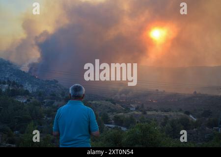 Athènes, Grèce. 12 août 2024. Les résidents observent le front de feu à l'approche de la banlieue de Penteli dans la capitale grecque. Un feu de forêt qui a éclaté à Varnavas le 11 août a continué de faire rage dans l'est de l'Attique le 12 août, attisant et s'étendant sur un front s'étendant sur plus de 20 kilomètres. Plusieurs pays ont répondu positivement à la demande d'assistance du mécanisme de protection civile de l'UE (EUCPM) formulée par les autorités grecques pour lutter contre les incendies de forêt qui font rage. Crédit : Dimitris Aspiotis/Alamy Live News Banque D'Images