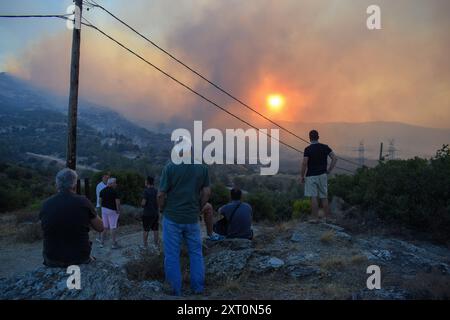 Athènes, Grèce. 12 août 2024. Les résidents observent le front de feu à l'approche de la banlieue de Penteli dans la capitale grecque. Un feu de forêt qui a éclaté à Varnavas le 11 août a continué de faire rage dans l'est de l'Attique le 12 août, attisant et s'étendant sur un front s'étendant sur plus de 20 kilomètres. Plusieurs pays ont répondu positivement à la demande d'assistance du mécanisme de protection civile de l'UE (EUCPM) formulée par les autorités grecques pour lutter contre les incendies de forêt qui font rage. Crédit : Dimitris Aspiotis/Alamy Live News Banque D'Images