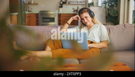 Femme, étudiant et ordinateur portable avec écouteurs à la maison pour l'apprentissage en ligne, la recherche de vidéos et l'étude pour le cours en ligne. Fille, Relax et casque avec Banque D'Images