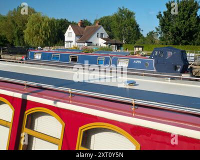 La zone autour de Sandford Lock Over the Thames est un endroit très apprécié des joggeurs, promeneurs, amateurs de chiens et beaucoup de gens fréquentant les grandes promenades dans cette région. Un nouveau boulanger artisanal proposant du pain au levain à la pointe est désormais une attraction locale... Ici, nous voyons des péniches amarrées par l'écluse, avec la maison d'écluse en arrière-plan, tôt un beau matin d'été. Je suis en route pour ramasser le pain. C'est le petit déjeuner trié, alors ! Banque D'Images