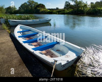 Fondé en 1921 et situé sur une belle partie de la Tamise dans l'Oxfordshire, Radley Boathouse sert Radley College et les amateurs d'aviron locaux depuis plus d'un siècle. Ici, nous voyons deux bateaux à rames amarrés par sa jetée, tôt par un beau matin d'été. Banque D'Images