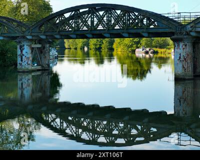 Une partie pittoresque de la Tamise qui rejoint Hinksey Stream à Kennington. Les pylônes géants abondent, et le Thames Path court à notre droite. La scène est dominée par un pont ferroviaire rouillé et abandonné, inutilisé depuis de nombreuses années. Tout brille avec la première lumière sur un beau matin de milieu d'été. Adorable. Banque D'Images