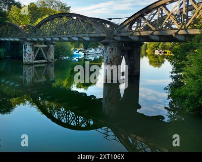 Une partie pittoresque de la Tamise qui rejoint Hinksey Stream à Kennington. Les pylônes géants abondent, et le Thames Path court à notre droite. La scène est dominée par un pont ferroviaire rouillé et abandonné, inutilisé depuis de nombreuses années. Tout brille avec la première lumière sur un beau matin de milieu d'été. Adorable. Banque D'Images