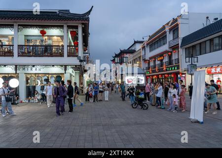 Suzhou, Chine - 11 juin 2024 : Une rue animée à Suzhou, Chine, avec une architecture traditionnelle, des piétons et des magasins. Banque D'Images