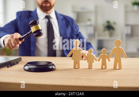 Gros plan de Judge Hands avec Gavel et figurines familiales en bois Banque D'Images