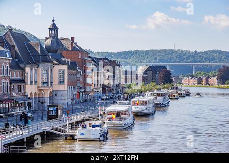 Dinant, Namur, Wallonie, Belgique. 5 juin 2024. Ville touristique de Dinant et rivière Meuse avec des bateaux ancrés aux quais de promenade, rue véhiculaire, construction Banque D'Images