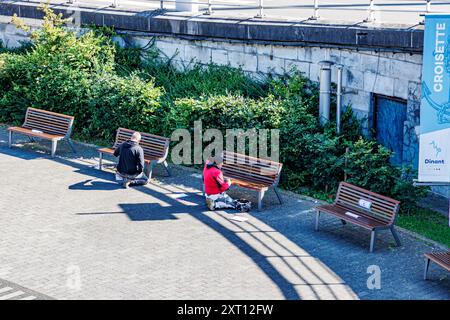 Dinant, Namur, Wallonie, Belgique. 6 juin 2024. Les ouvriers de la mairie laquent des bancs en bois sur la place publique à côté du pont de véhicules, travail manuel, vert Banque D'Images