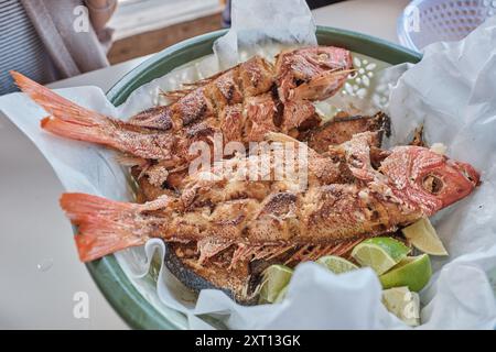 D'en haut de poisson frit appétissant avec des tranches de citron servies dans un bol placé sur la table au restaurant Banque D'Images