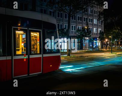 Tram illumine les rues avec des phares la nuit à Vienne, Autriche. Banque D'Images