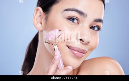 Beauté, rouleau facial et portrait de femme en studio avec routine de drainage lymphatique pour l'amincissement. Soins de la peau, quartz rose et personne avec outil en cristal Banque D'Images