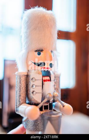 Poupée casse-noisette avec barbe blanche et manteau argenté battant les tambours Banque D'Images