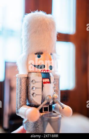 Casse-noisette blanc décoratif avec fourrure blanche Bearskin Hat un costume argenté et un tambour debout sur une table avec une bouche ouverte Banque D'Images