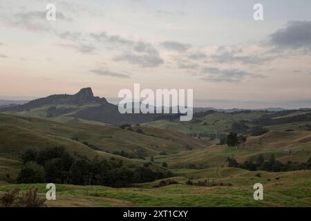 Lever du soleil sur une colline tranquille et vallonnée avec une formation rocheuse distinctive au loin sous un ciel pastel. Evpe00605 Copyright : xConnectxImagesx Banque D'Images