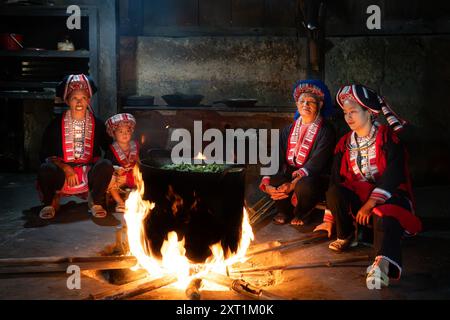 Trois générations d'une famille de tribu Red Dao Hill cuisinent dans leur cuisine dans le district de Hoang Su Phi de la province de Ha Giang, au nord du Vietnam Banque D'Images