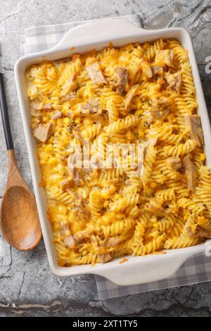 Casserole de thon cuite avec pâtes fusilli, sauce crémeuse Mornay et gros plan de maïs sur le plat de cuisson sur la table. Vue de dessus verticale Banque D'Images