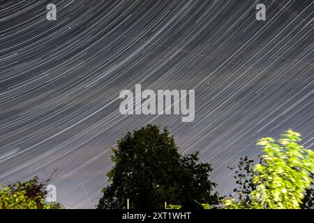 Londres, Royaume-Uni. 13 août 2024. Météo britannique – Une image composite, de minuit à 2h20, montrant les météores de la douche Perséid, le mouvement des étoiles ainsi que les lumières des avions aux premières heures près de Watford, au nord-ouest de Londres. La pluie de météores Perséides est le résultat du passage de la Terre à travers un nuage de poussière laissé derrière la comète Swift-Tuttle. Credit : Stephen Chung / Alamy Live News Banque D'Images