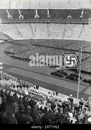 Une photographie montre la Jeunesse hitlérienne réunie devant Adolf Hitler le 1er mai. Cet événement faisait partie des efforts du régime nazi pour présenter et endoctriner la jeunesse allemande, soulignant leur loyauté et leur engagement envers le Führer et les idéaux du troisième Reich. L'image reflète l'accent mis par le régime sur la formation de la prochaine génération pour faire avancer son idéologie. Banque D'Images