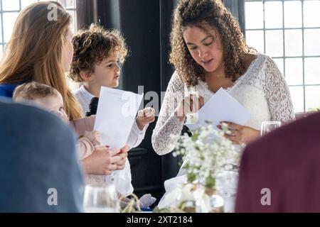 Un groupe de personnes engagées dans une discussion animée autour d'une table avec des documents en main. Panc05853 Copyright : xConnectxImagesx Banque D'Images