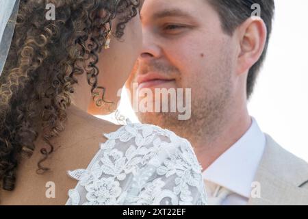 Gros plan d'une mariée et mariée partageant un moment intime, avec l'accent sur leurs profils et le détail de robe de dentelle de la mariée. Panc05981 Copyright : xConnec Banque D'Images