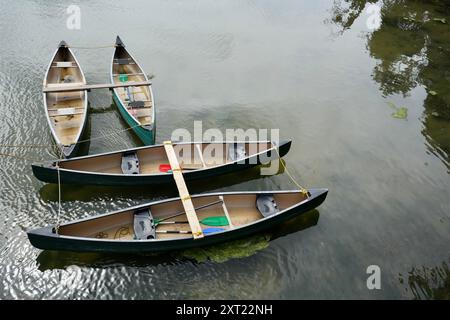 4 canoës vides attachés sur une rivière. Banque D'Images