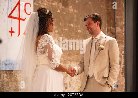 La mariée et le marié se tiennent la main pendant la cérémonie de mariage avec un fond d'art graffiti. Panc06046 Copyright : xConnectxImagesx Banque D'Images
