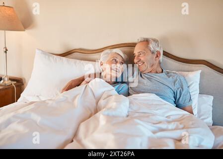 Couple aîné, heureux et couché avec retraite, calme et repos le matin dans une maison de retraite. Mariage, soins et amour avec sieste ensemble dans la chambre Banque D'Images