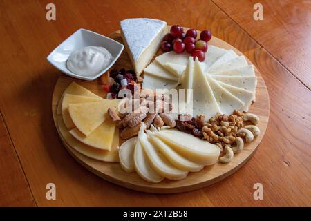 Tableau des différents fromages présentés avec des raisins, des noix, quelques feuilles de menthe et des fleurs de lavande Banque D'Images