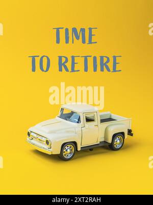 Un camion-jouet est assis sur un fond jaune avec les mots Time to Remarque écrits en dessous Banque D'Images