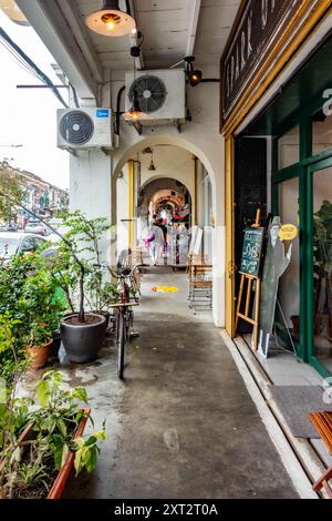 Un sentier couvert le long de la rue Chulia à George Town, Penang, Malaisie avec des plantes en pot d'un côté. Banque D'Images