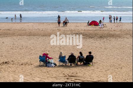 Bridlington, East Yorkshire, 13 août 2024. Une famille profite du temps chaud sur Bridlington South Beach. Certaines parties du Royaume-Uni connaissent actuellement une vague de chaleur courte mais intense en raison des effets de Tropical Story Debby qui a frappé des parties des Caraïbes et des États-Unis au cours du week-end. Crédit : Michael Jamison/Alamy Live Nouveau Banque D'Images