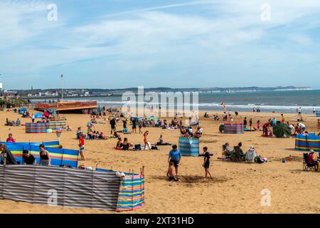 Bridlington, East Yorkshire, 13 août 2024. Les Beacbgoers apprécient le temps chaud sur Bridlington South Beach. Certaines parties du Royaume-Uni connaissent actuellement une vague de chaleur courte mais intense en raison des effets de Tropical Story Debby qui a frappé des parties des Caraïbes et des États-Unis au cours du week-end. Crédit : Michael Jamison/Alamy Live News Banque D'Images