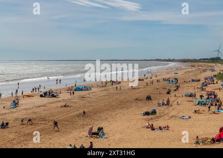 Bridlington, East Yorkshire, 13 août 2024. Les Beacbgoers apprécient le temps chaud sur Bridlington South Beach. Certaines parties du Royaume-Uni connaissent actuellement une vague de chaleur courte mais intense en raison des effets de Tropical Story Debby qui a frappé des parties des Caraïbes et des États-Unis au cours du week-end. Crédit : Michael Jamison/Alamy Live News Banque D'Images