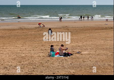 Bridlington, East Yorkshire, 13 août 2024. Les Beacbgoers apprécient le temps chaud sur Bridlington South Beach. Certaines parties du Royaume-Uni connaissent actuellement une vague de chaleur courte mais intense en raison des effets de Tropical Story Debby qui a frappé des parties des Caraïbes et des États-Unis au cours du week-end. Crédit : Michael Jamison/Alamy Live Nouveau Banque D'Images