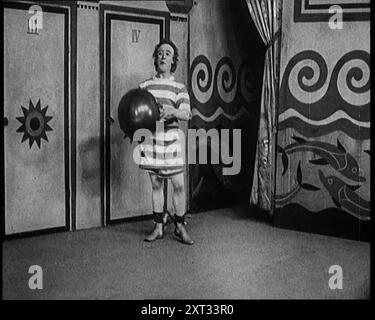 Stanley Lupino se produisant dans un spectacle à Londres portant un maillot de bain rayé, 1922. De "Time to Remember - Sitting Still and Going Slowly", 1922 (Reel 2) ; revue des événements de 1922, y compris les troubles irlandais, la guerre entre la Grèce et la Turquie et les développements dans l'aviation et la radio. Banque D'Images