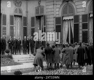 Nouveau gouvernement français debout photographié, filmé et interviewé par des journalistes, années 1920 '...la France, encore une fois en proie à des troubles politiques, avec un nouveau gouvernement tous les deux mois...'. De "Time to Remember - came the Dawn", 1925 (Reel 3) ; aperçu de l'industrie cinématographique britannique des années 1920 - extraits de grands films muets et de nouvelles. Banque D'Images