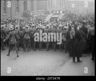 Soldats britanniques retenant des foules de manifestants à Dublin alors qu'un char se déplace pour les briser, 1920. 'Devant la prison Mountjoy de Dublin, qui tenait tant de leurs amis, des foules en colère ont montré l'esprit de leur ville en manifestant que seuls de lourds blindés pouvaient se briser. Mais cet esprit pourrait-il vraiment être brisé?". De "Time to Remember - The Plunge into Peace", 1920 (bobine 4) ; événements de 1920 - mariages, droits des femmes, troubles sociaux et problèmes en Irlande Banque D'Images